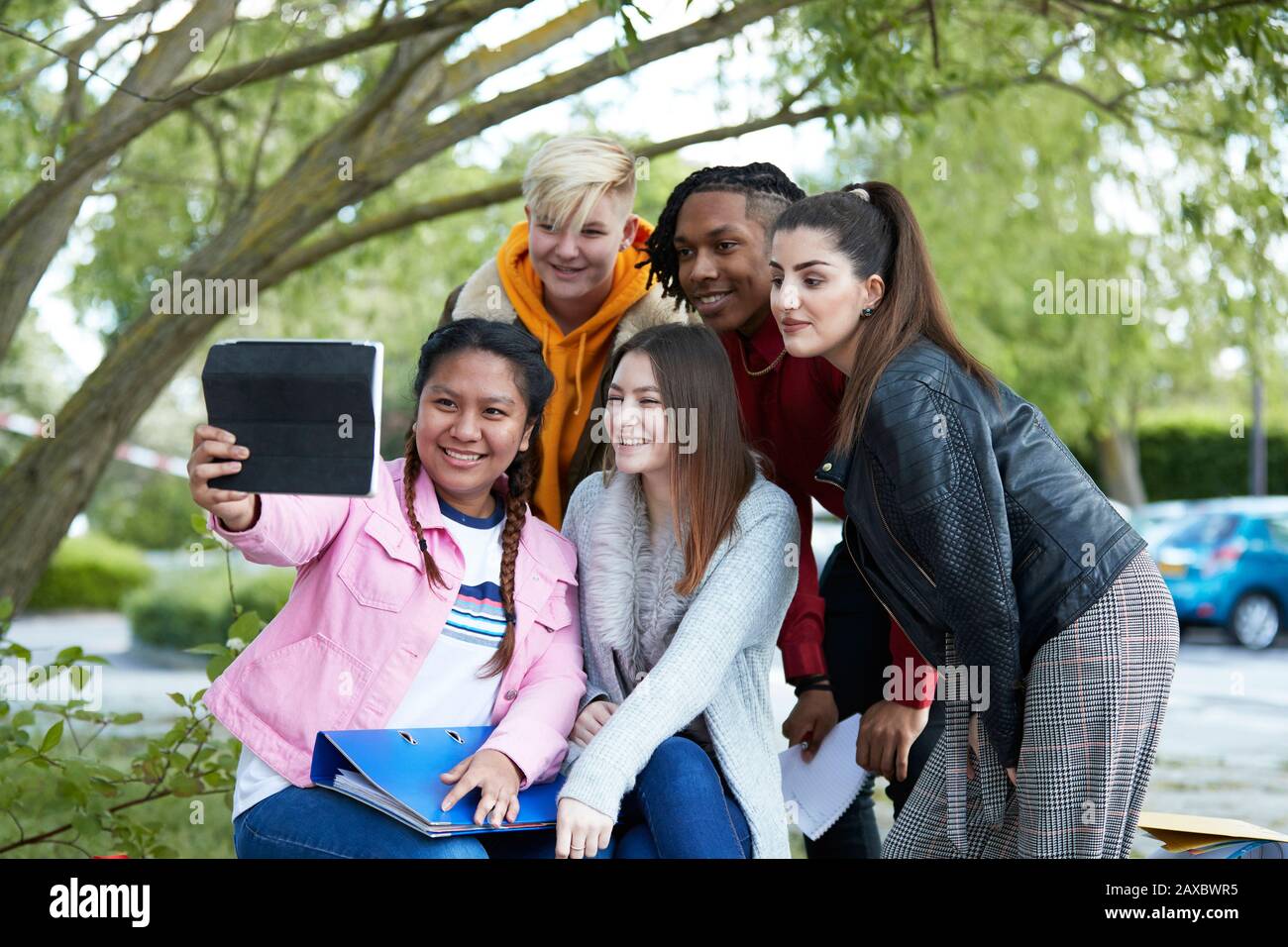 Gli studenti dell'università felici che prendono selfie con il tablet digitale nel parco Foto Stock