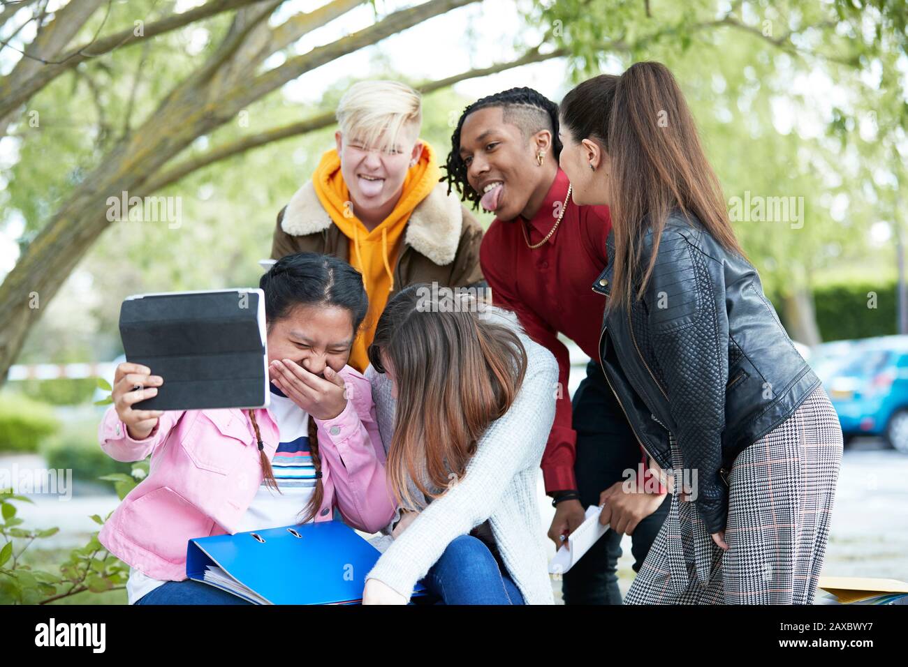 Giocoso felice università studenti amici digitale tablet selfie parco Foto Stock