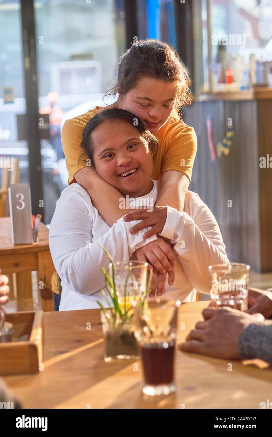 Ritratto felice affettuoso giovani donne con sindrome Di Down in caffè Foto Stock
