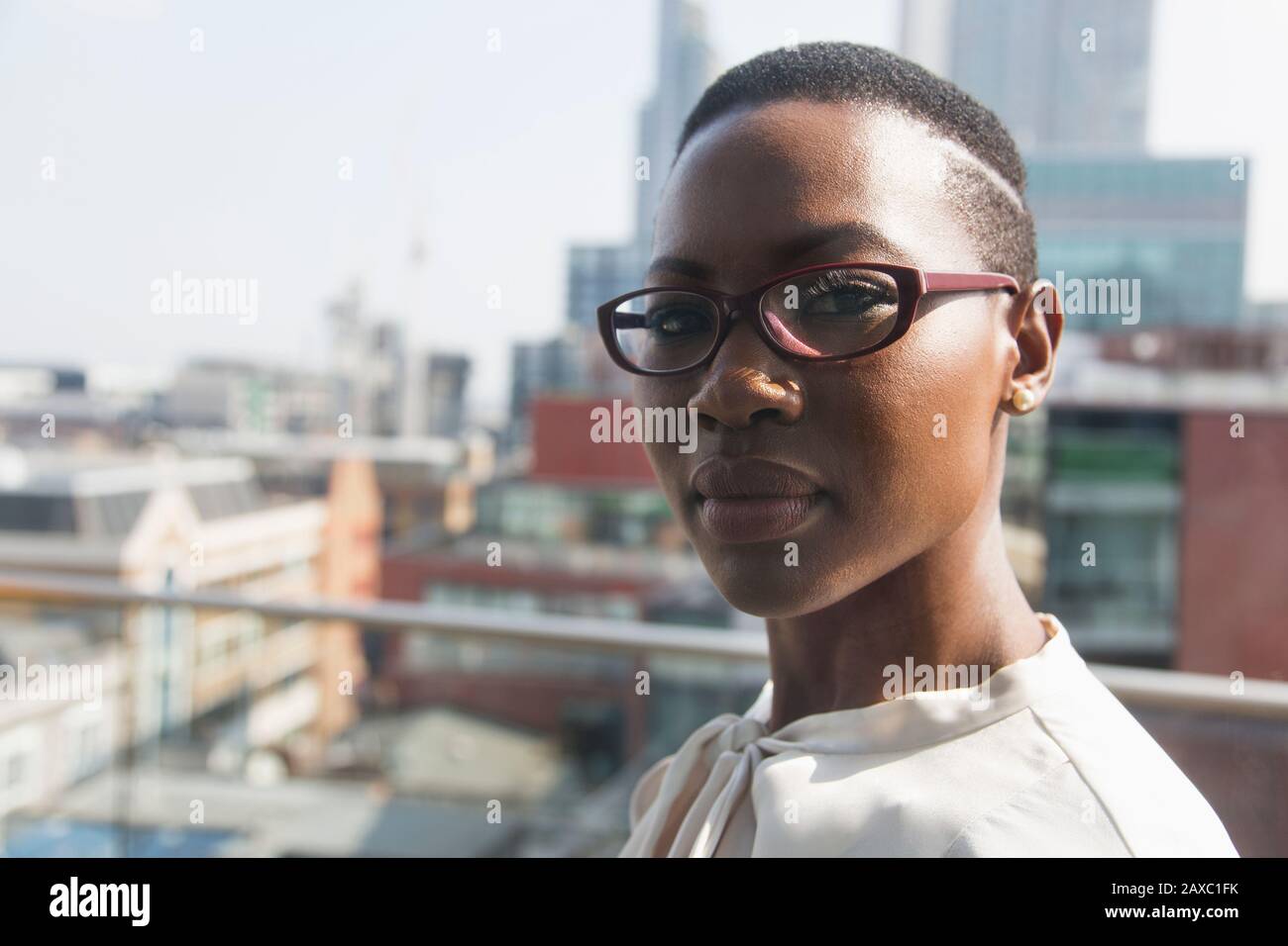 Primo piano ritratto sicuro businesswoman su soleggiato, urbano alto balcone Foto Stock
