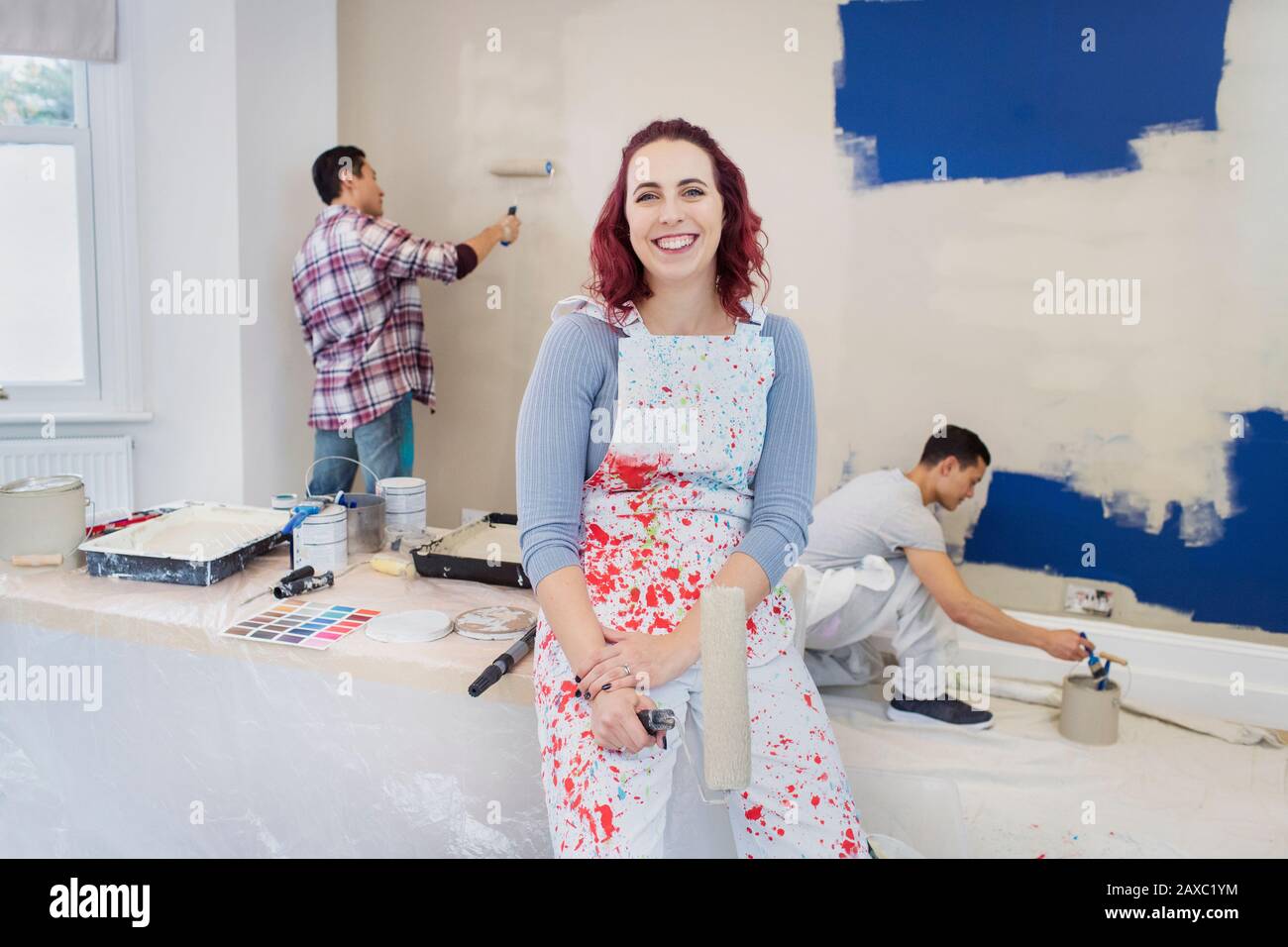 Ritratto sicuro donna in tuta pittura camera con gli amici Foto Stock