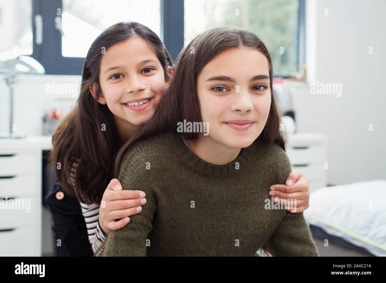 Ritratto felice, affettuoso sorelle a casa Foto Stock