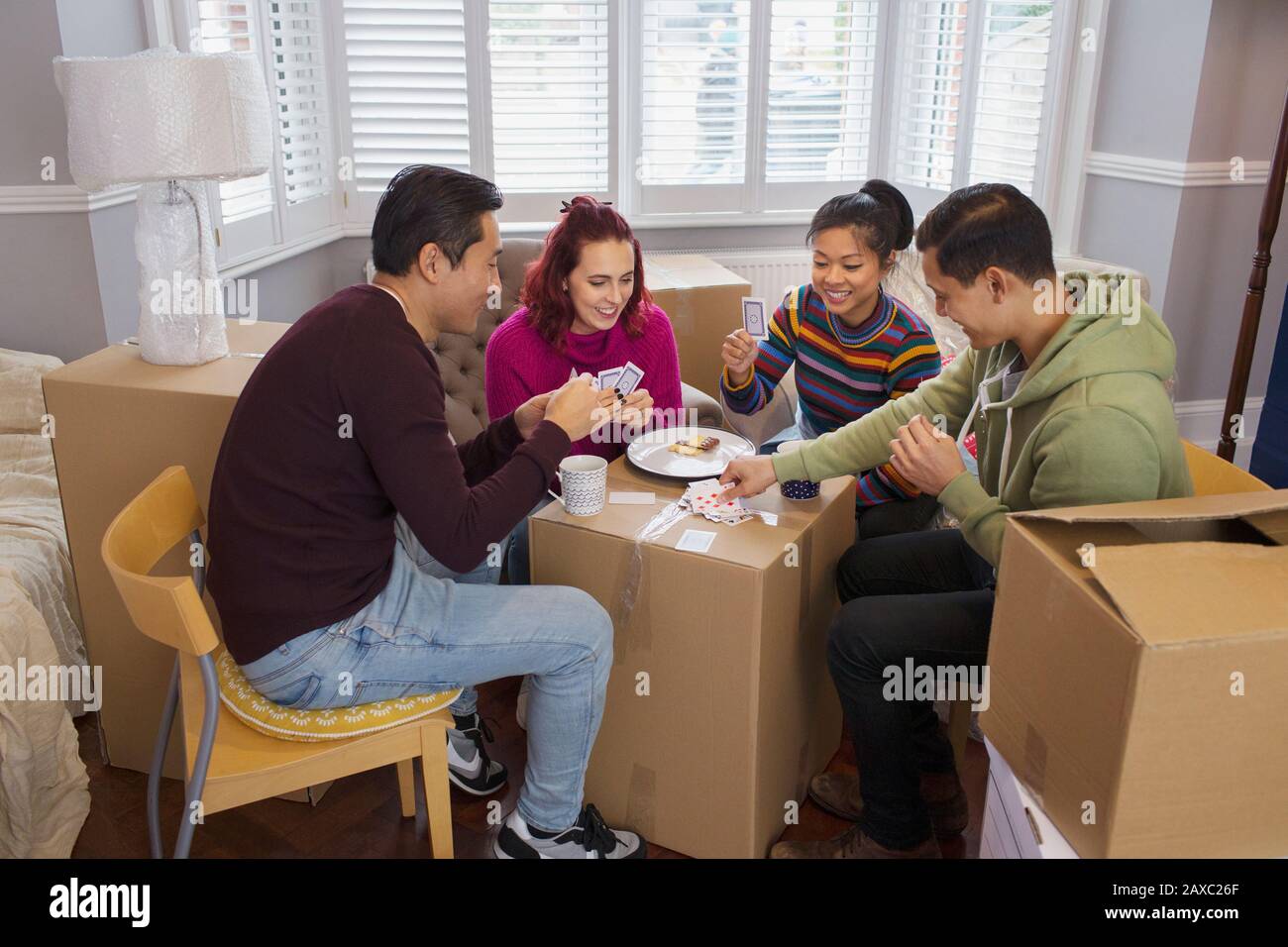 Amici che prendono una pausa dal movimento, giocando le carte Foto Stock