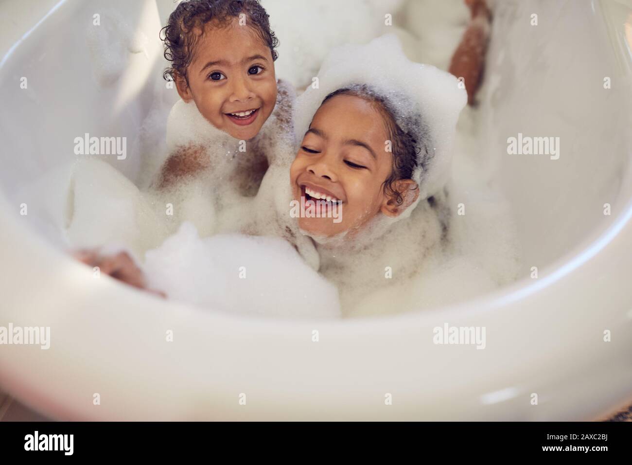 Ritratto sorelle giocose godendo bagno bolla Foto Stock