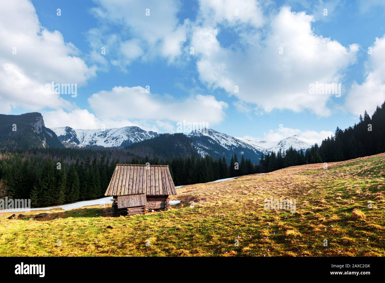 Vecchia capanna di legno e cielo nuvoloso in primavera alta Tatra montagne in Kalatowki prato, Zakopane, Polonia. Fotografia di paesaggio Foto Stock