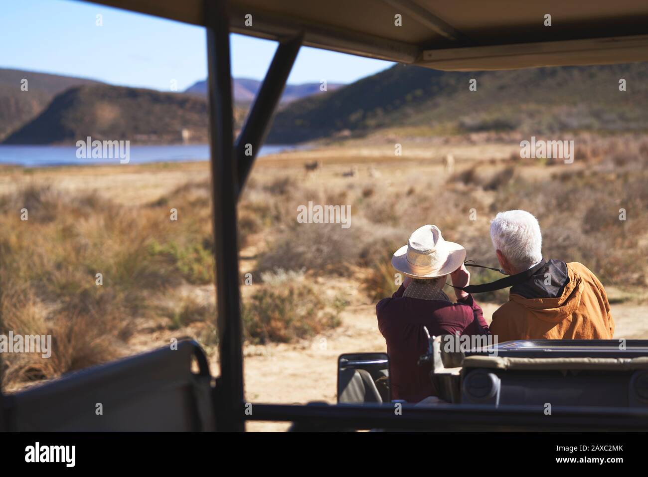Coppia senior in safari guardando fuori dal veicolo fuoristrada Foto Stock