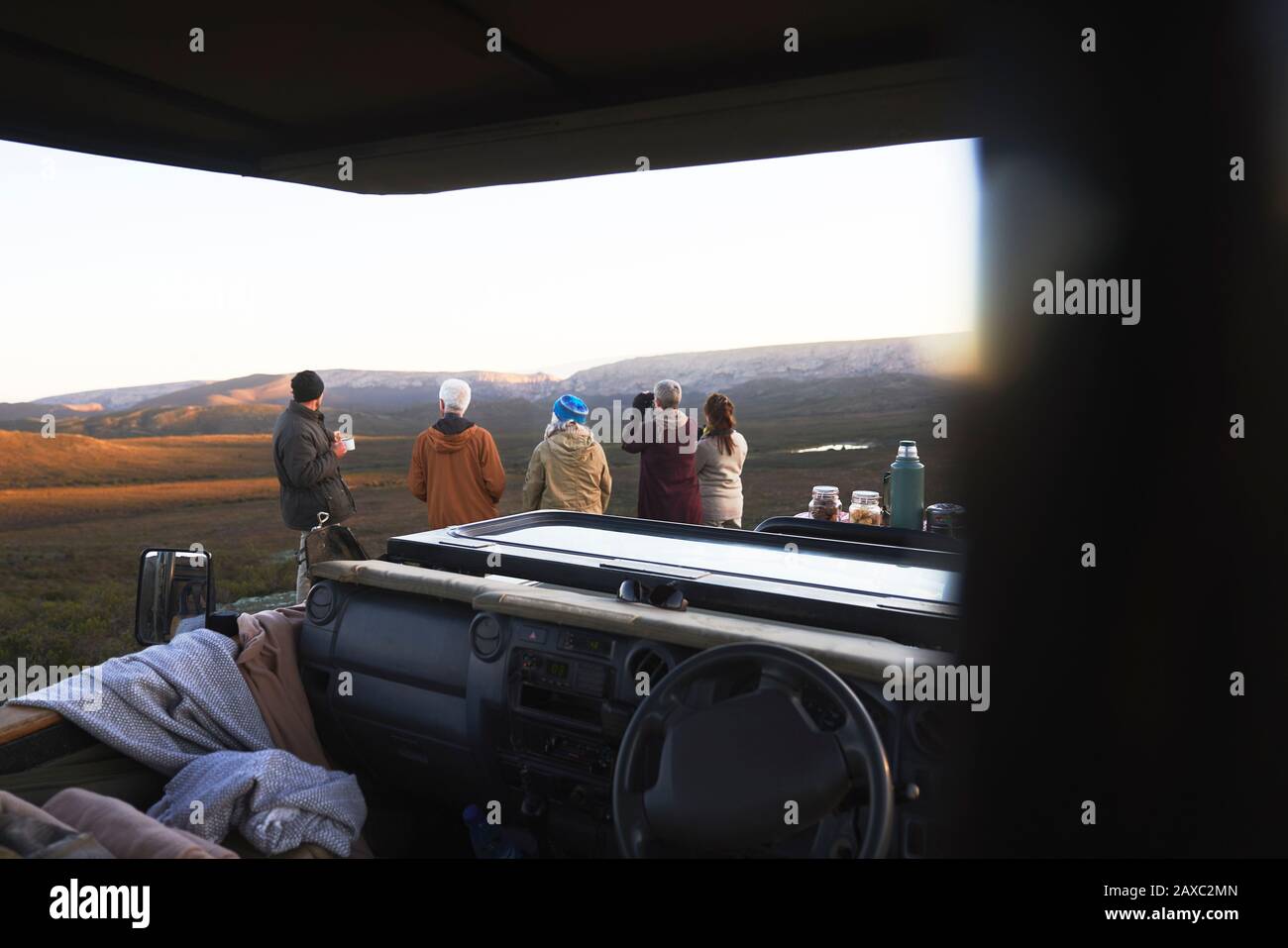 Gruppo Safari che guarda la vista panoramica fuori dal veicolo fuoristrada Foto Stock