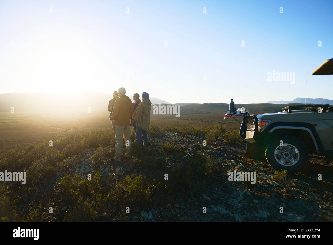 Tour in Safari per gruppi che godono di un'idilliaca alba dalla collina del Sud Africa Foto Stock