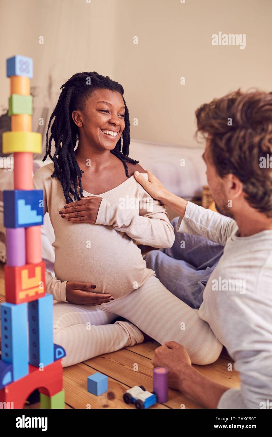 Felice incinta coppia che parla Foto Stock