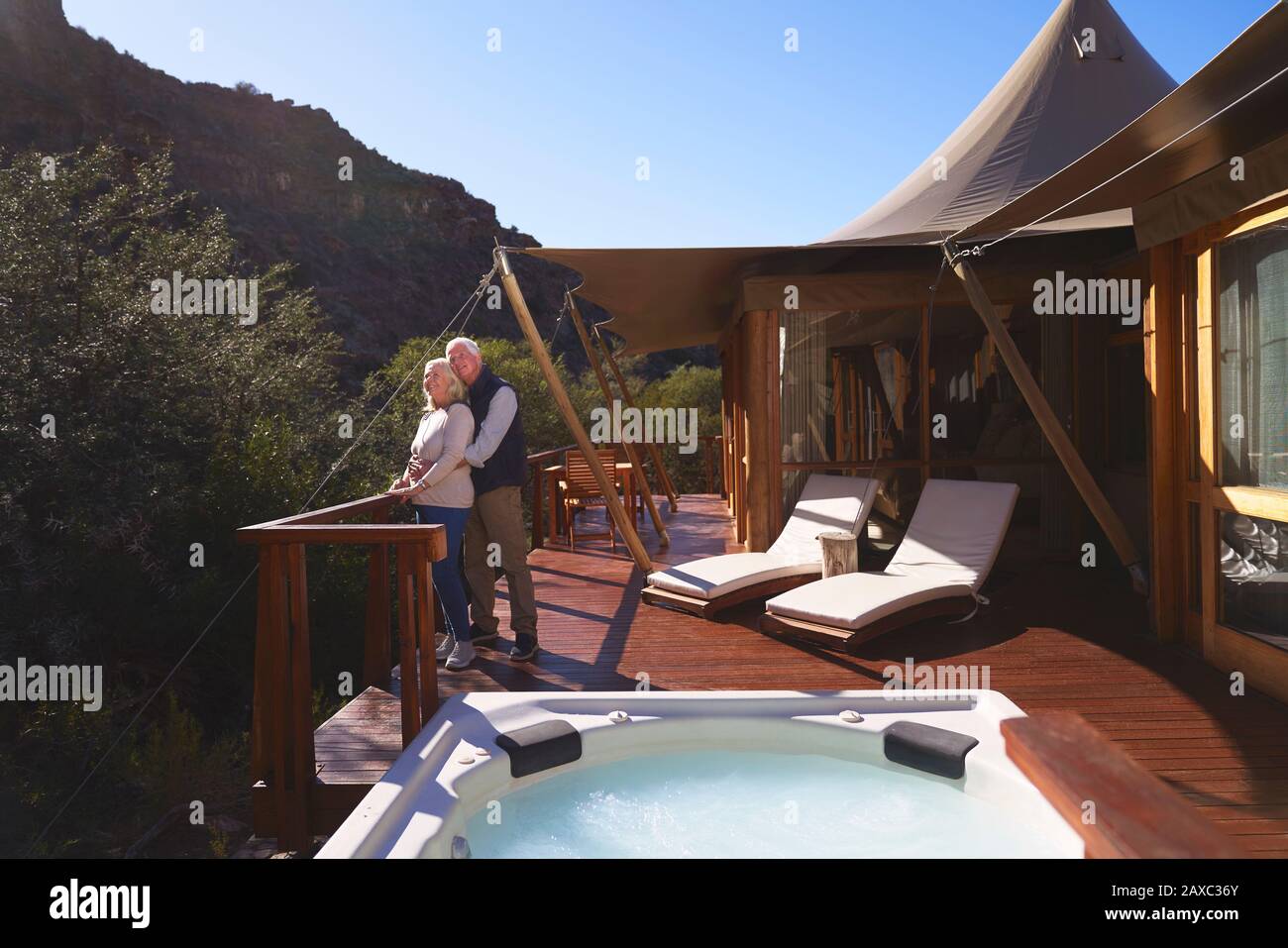 Affettuoso senior coppia sul soleggiato e lussuoso balcone Lodge safari Foto Stock