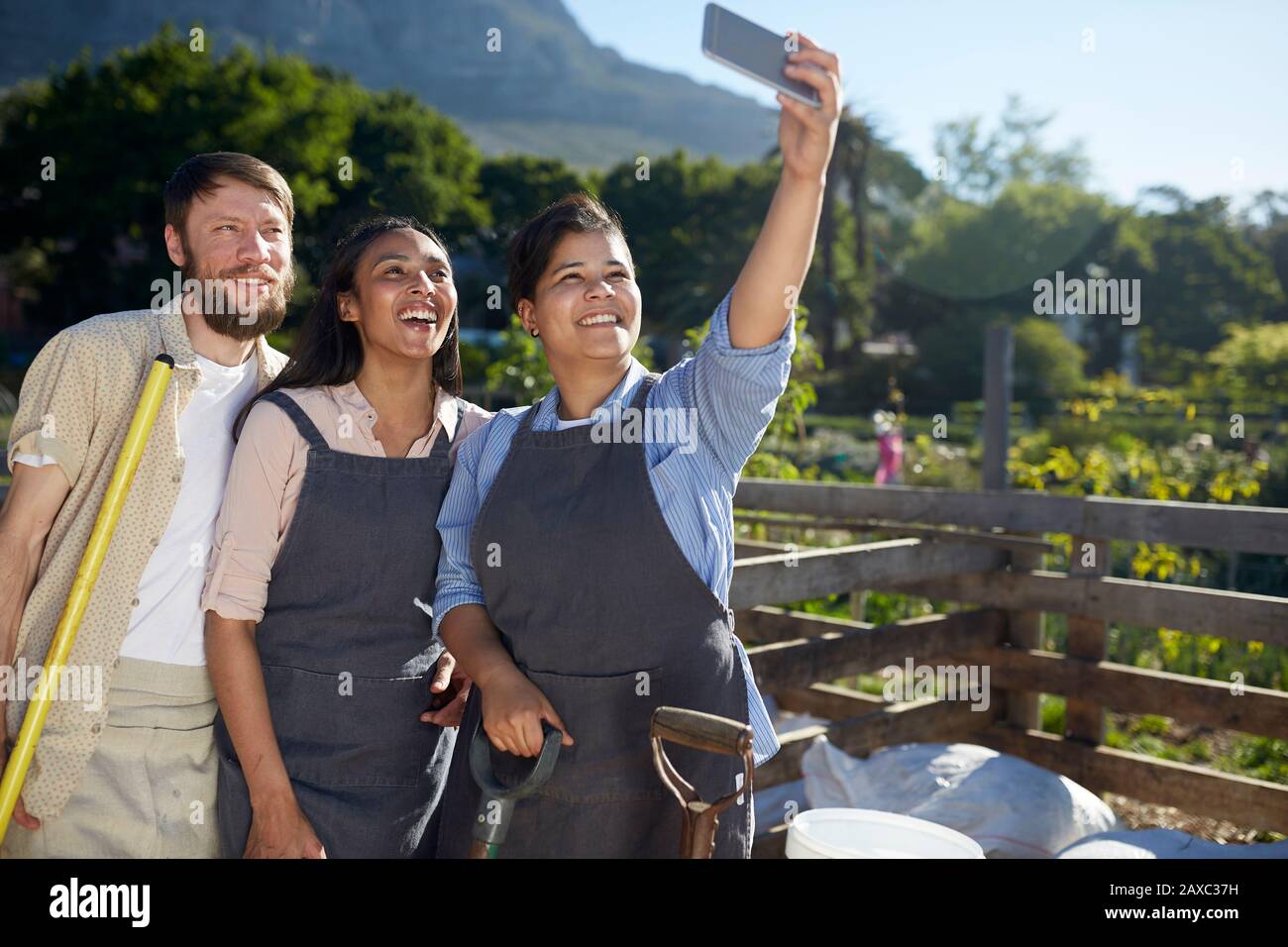 Lavoratori che posano per selfie al vivaio di piante soleggiate Foto Stock