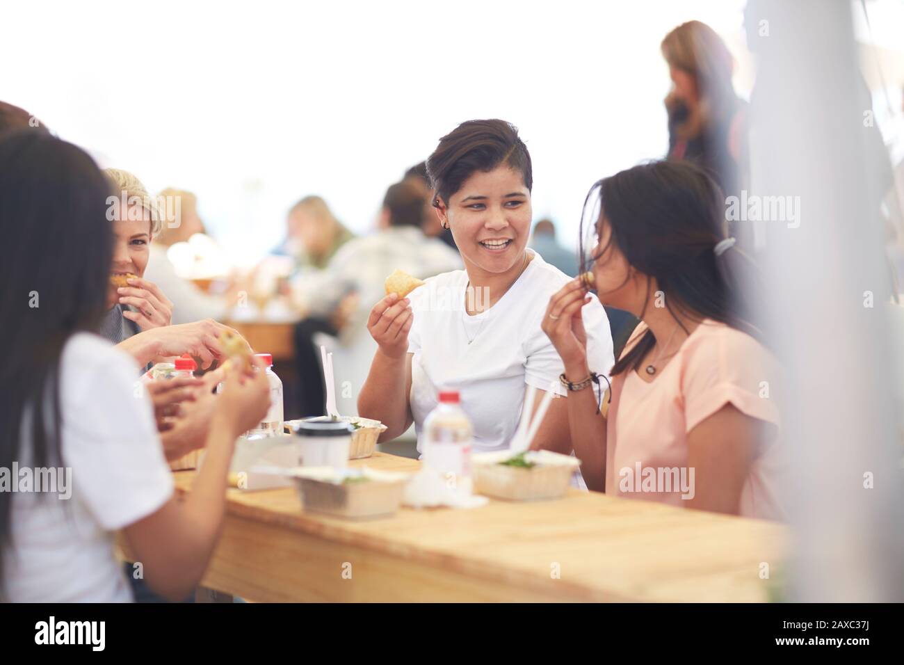 Amici che gustano il pranzo al mercato contadino Foto Stock