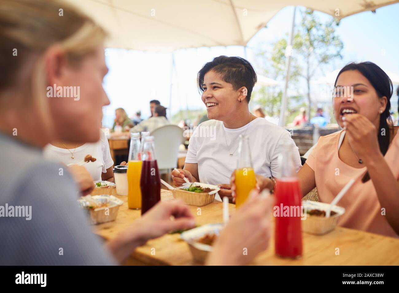 Sorridendo le donne amiche che si gustano il pranzo al mercato contadino Foto Stock