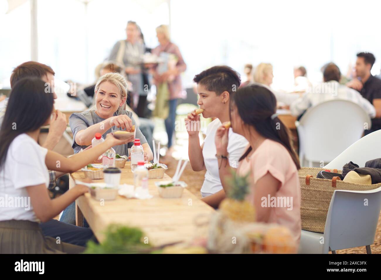 Amici che gustano il pranzo al mercato contadino Foto Stock