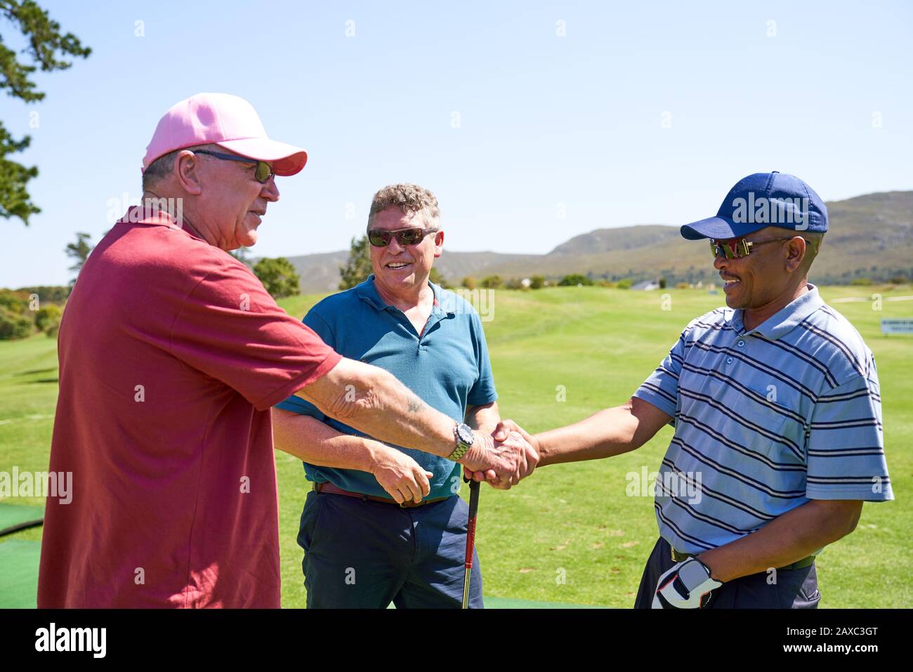 I golfers maschili scuotono le mani sul campo da golf soleggiato Foto Stock