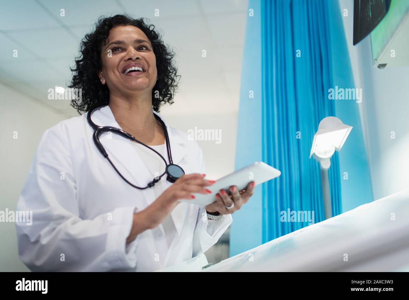 Medico felice femminile con tablet digitale in ospedale Foto Stock