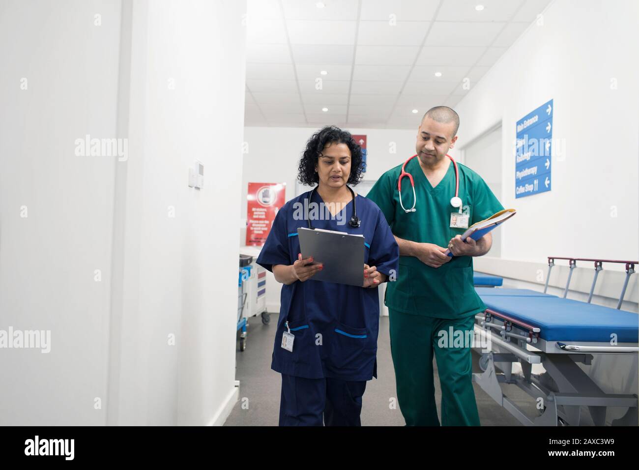 Medici con carta medica che fa giri nel corridoio dell'ospedale Foto Stock