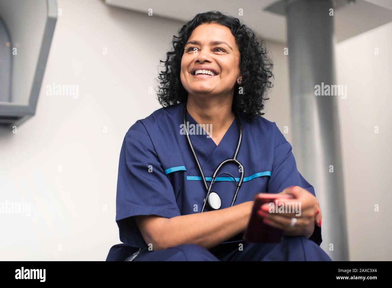 Ritratto sorridente, medico felice femminile utilizzando smartphone Foto Stock