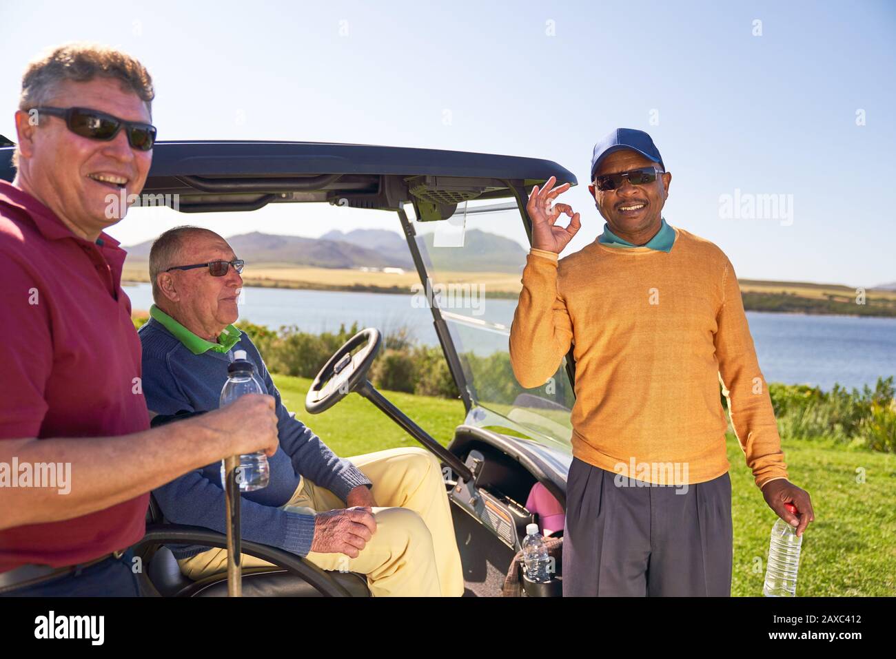 Ritratto felice fiducioso maschio golfista gesturing al soleggiato campo da golf Foto Stock