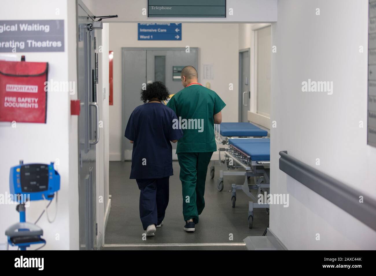 Medico e chirurgo che cammina nel corridoio dell'ospedale Foto Stock