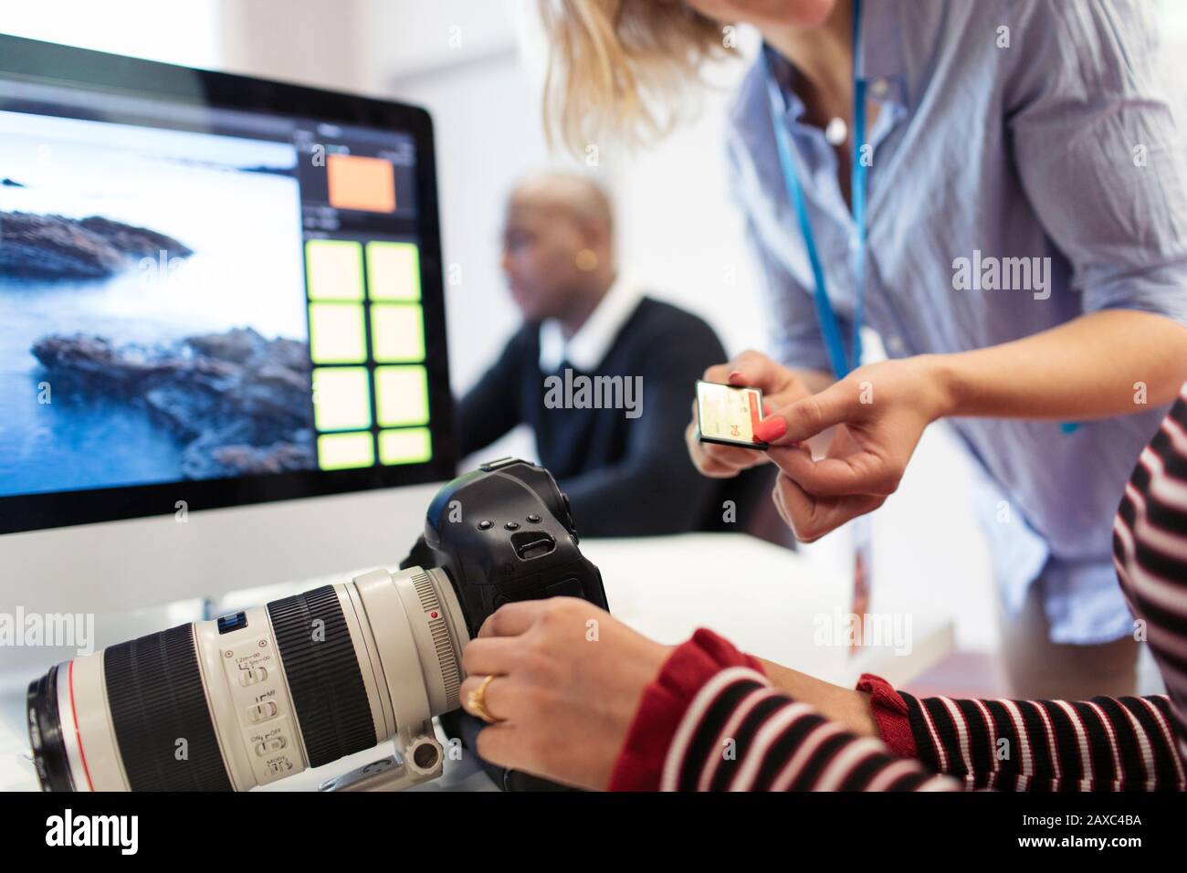 Studenti di fotografia con fotocamera digitale e scheda di memoria sul computer Foto Stock