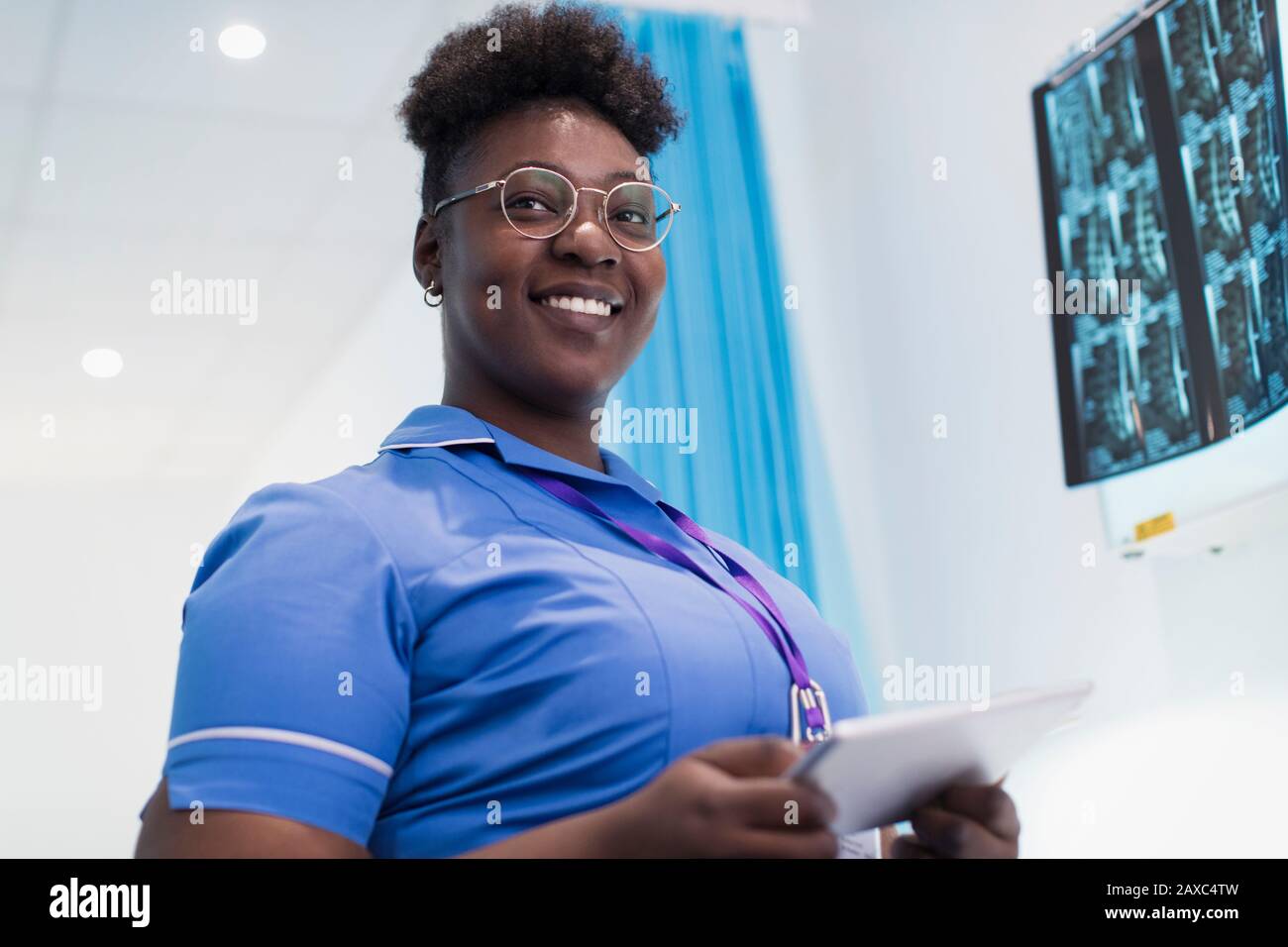 Infermiera femminile con immagine ritratto e sicura con tablet digitale che esamina i raggi X nella sala ospedaliera Foto Stock