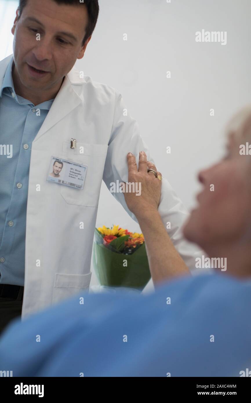 Paziente che tocca il braccio del medico nella sala ospedaliera Foto Stock