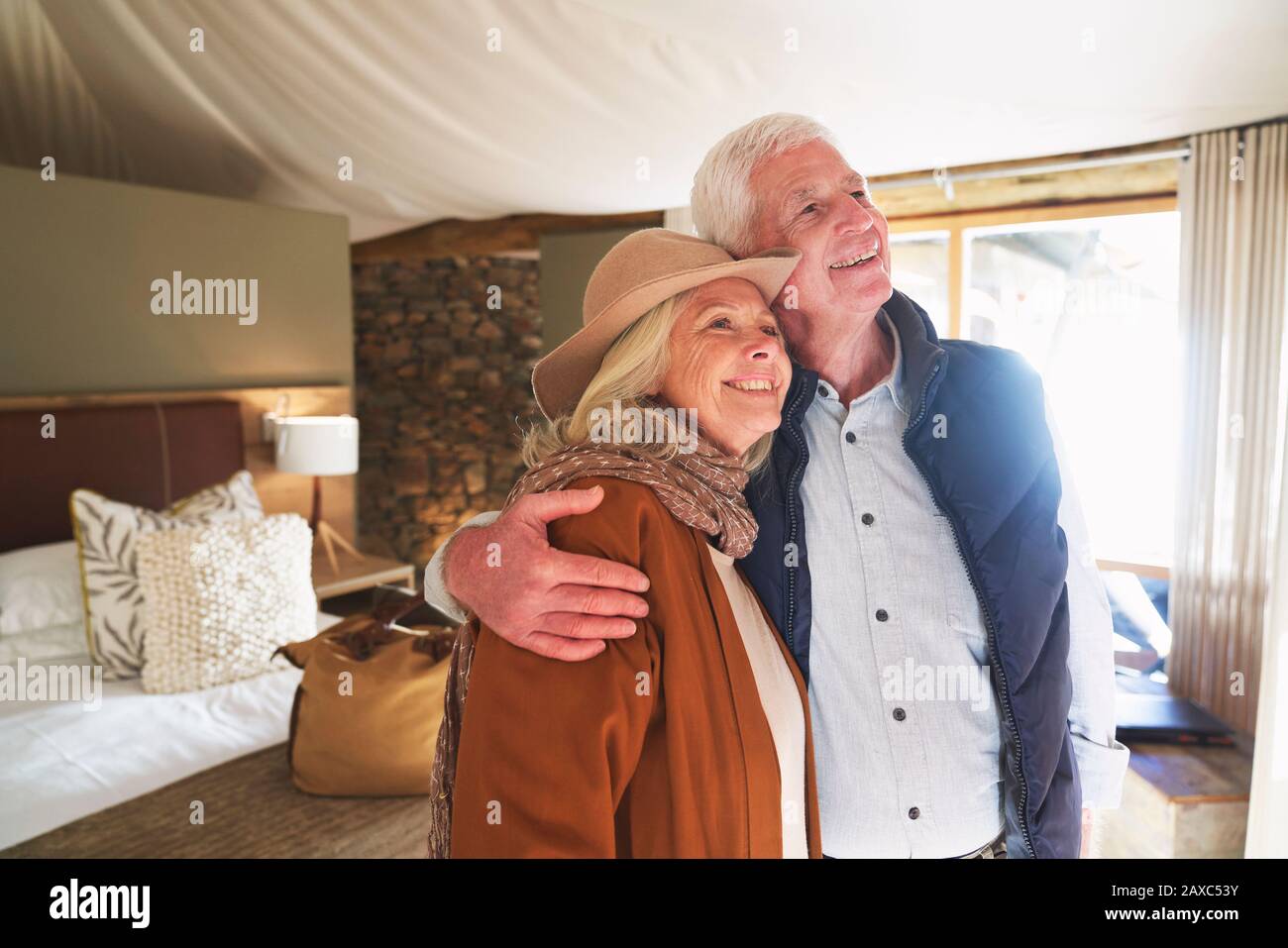 Spensierate coppie senior abbracciando in safari Lodge camera d'hotel Foto Stock