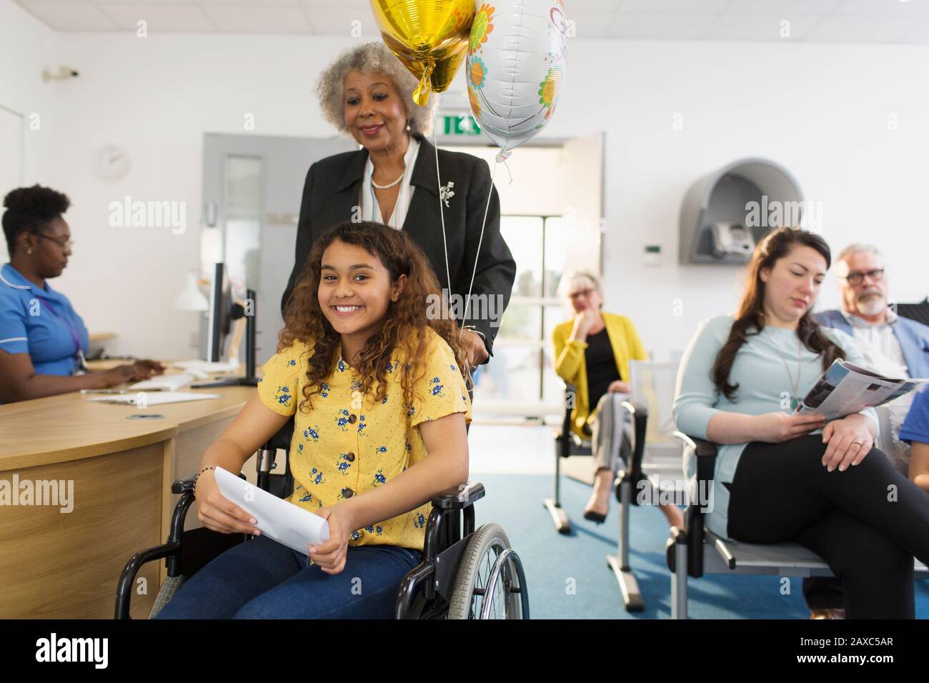 Ritratto ragazza sorridente paziente in sedia a rotelle in clinica Foto Stock