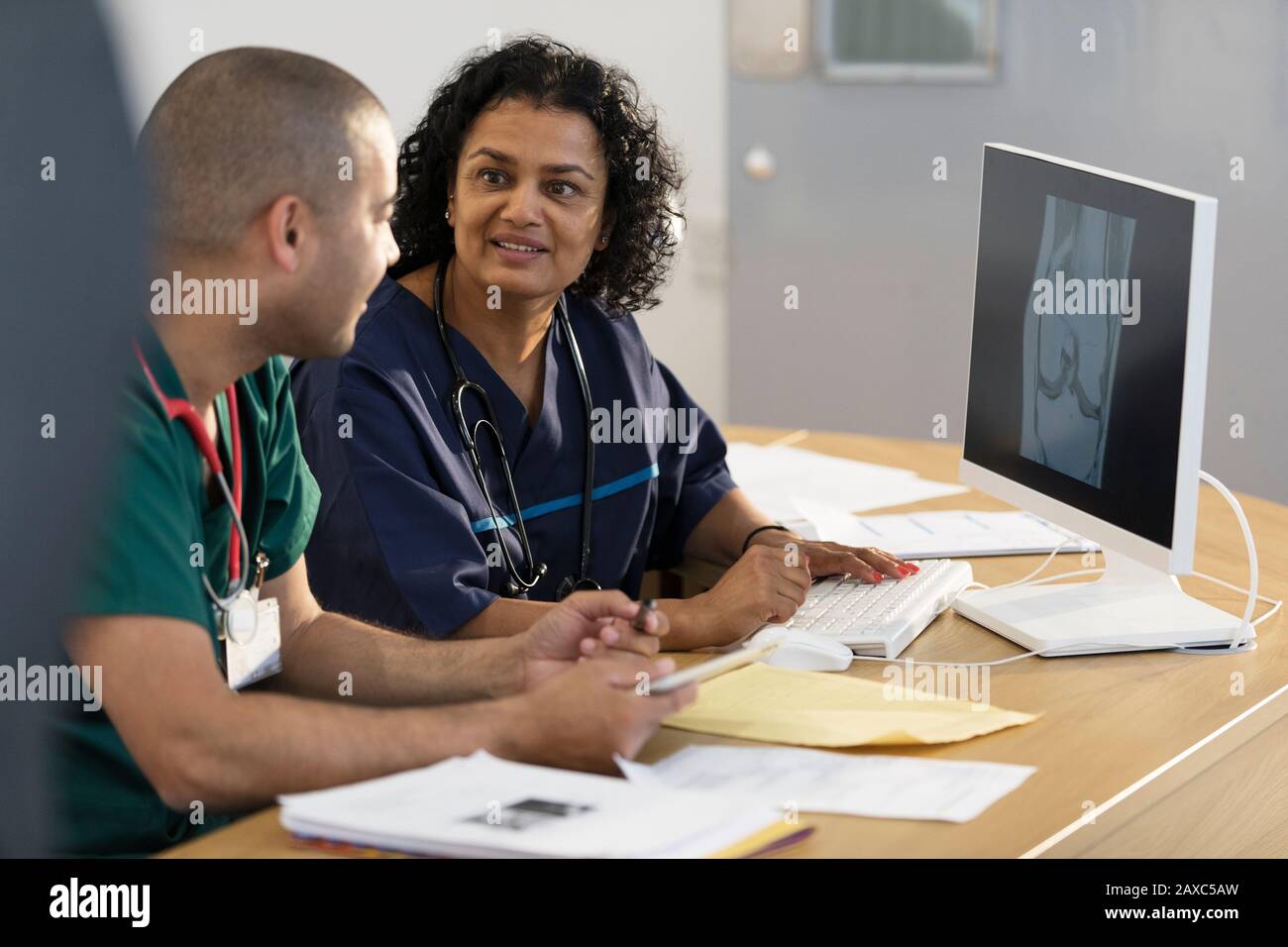 Medici che guardano i raggi X digitali sul computer in ufficio medici Foto Stock