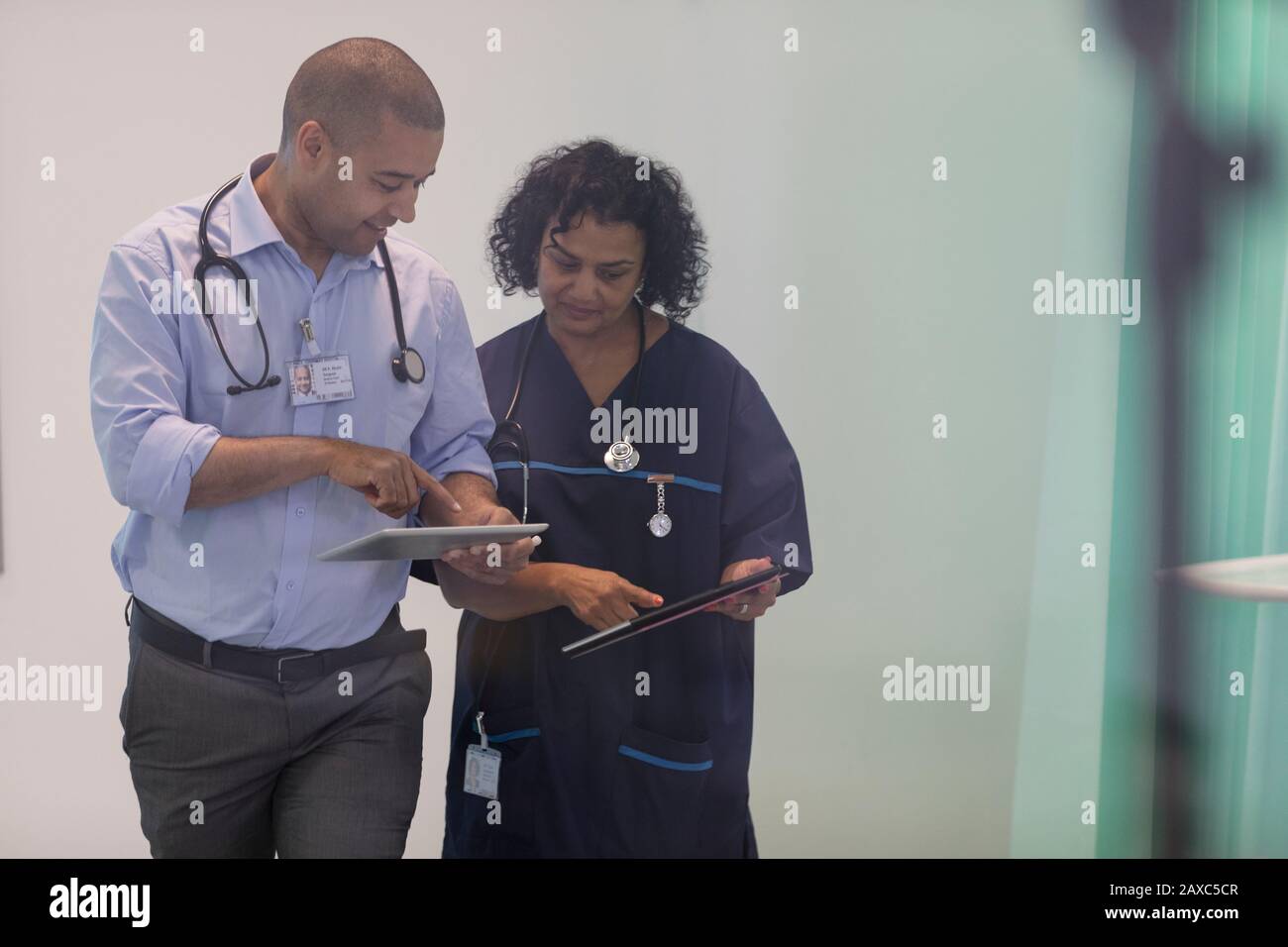 Medici con tablet digitali che parlano in ospedale Foto Stock