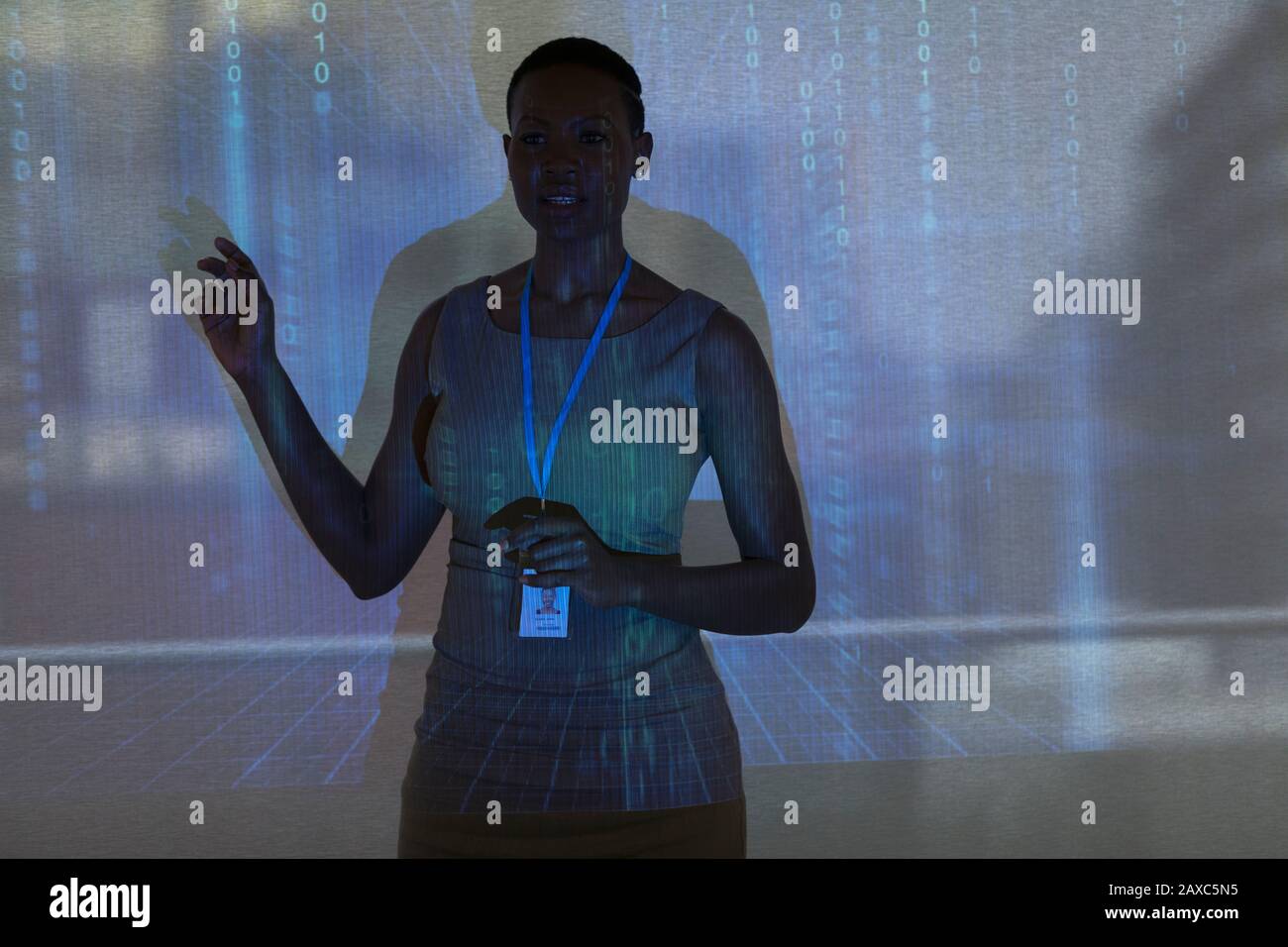 Businesswoman incontro principale a schermo di proiezione con codice binario Foto Stock