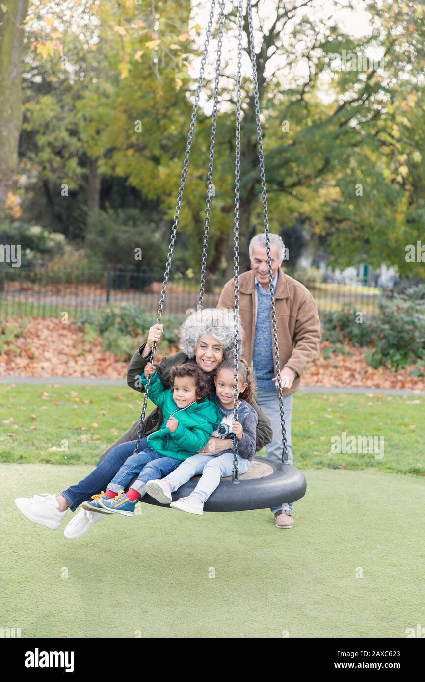 Nonni e nipoti che giocano a ruota nel parco Foto Stock
