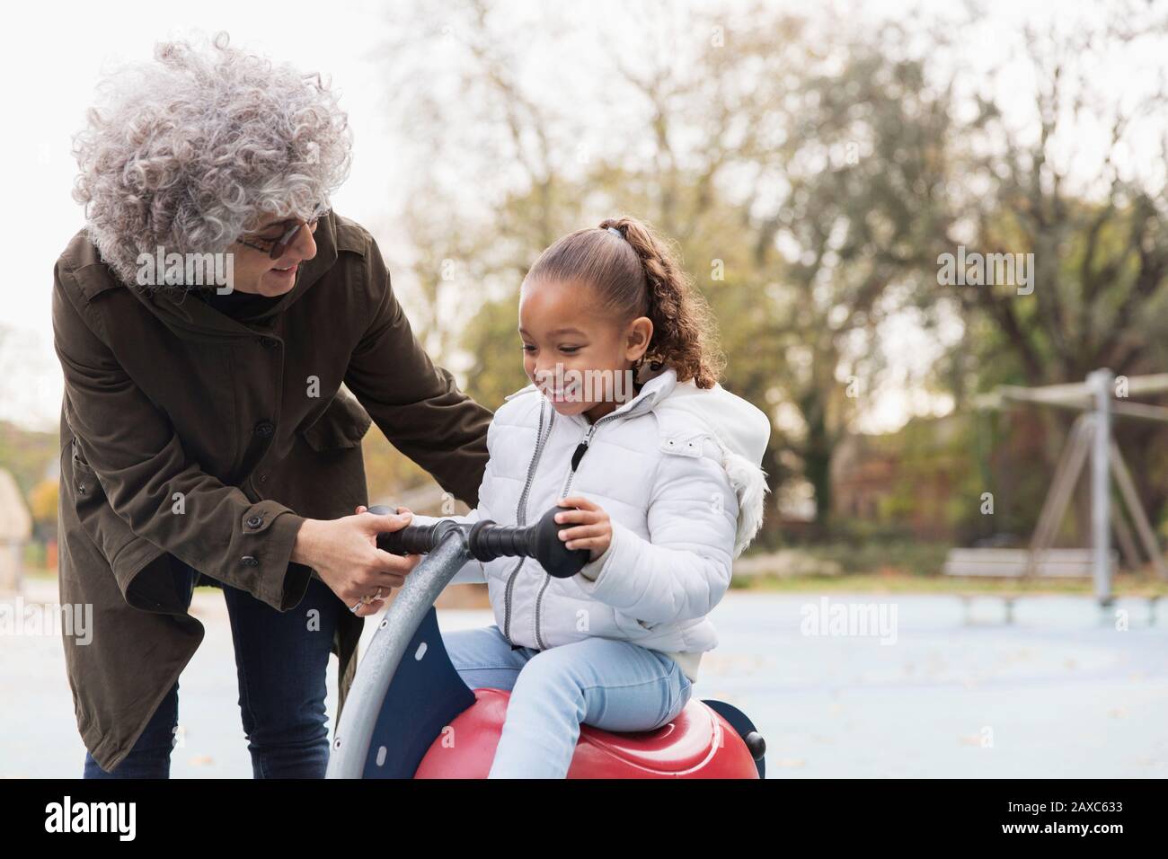 Nonna che gioca con la nipote al parco giochi Foto Stock