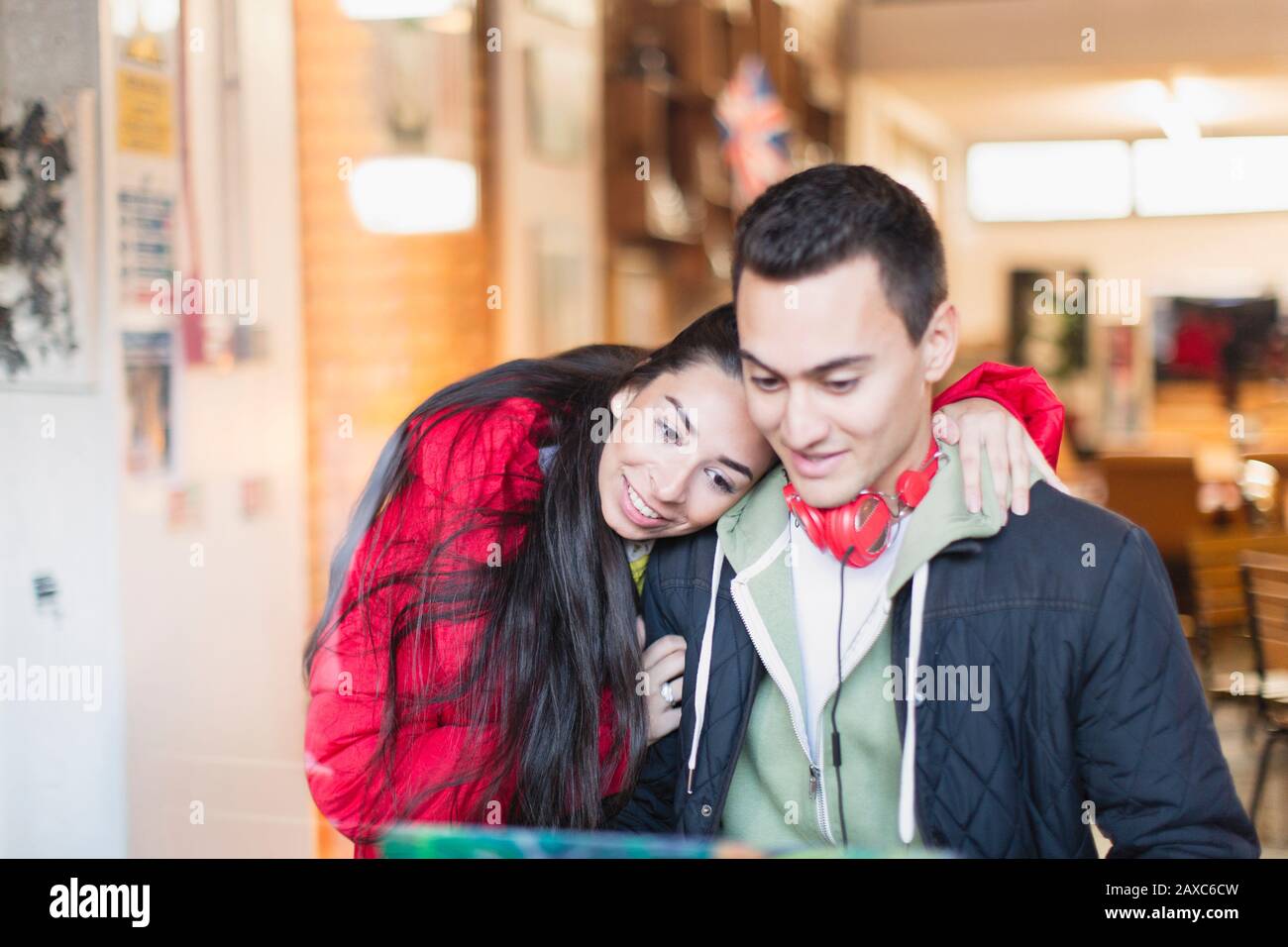 Coppia giovane utilizzando laptop in cafe Foto Stock