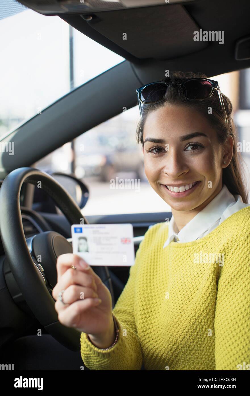 Ritratto giovane donna felice che detiene la patente di guida in auto Foto Stock
