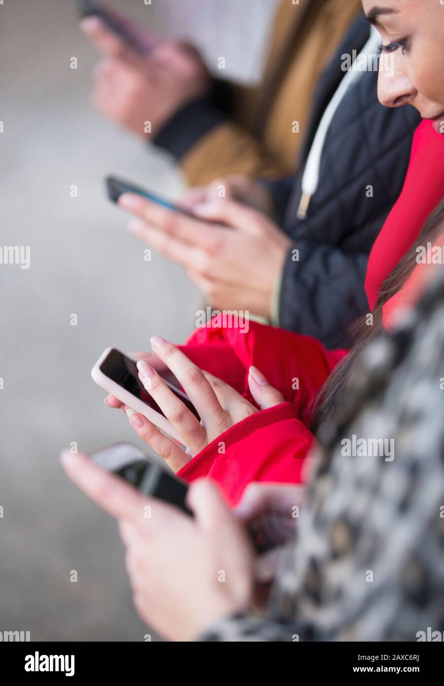 I giovani adulti utilizzando i telefoni intelligenti Foto Stock