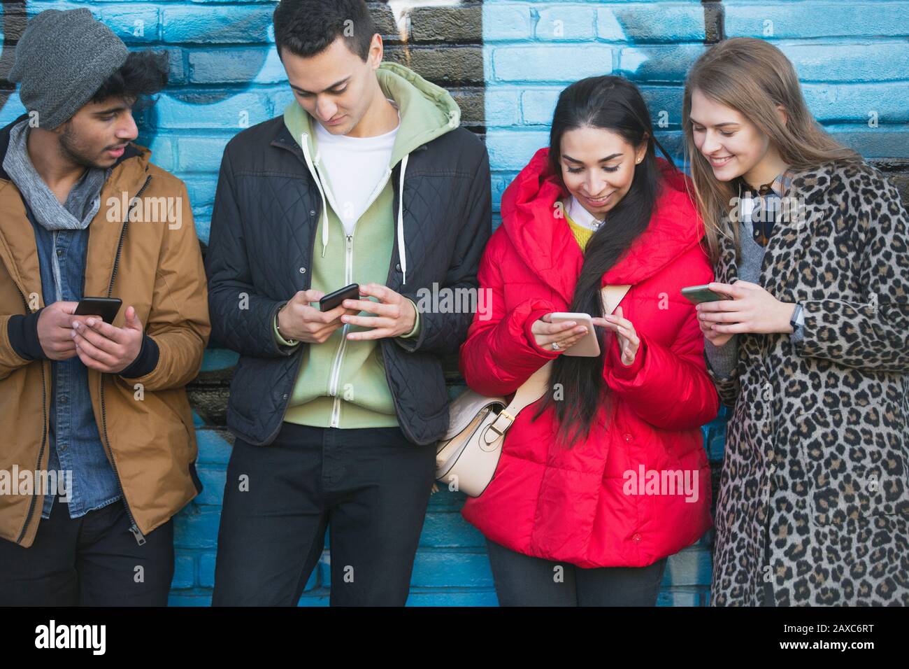 I giovani adulti utilizzando i telefoni intelligenti Foto Stock