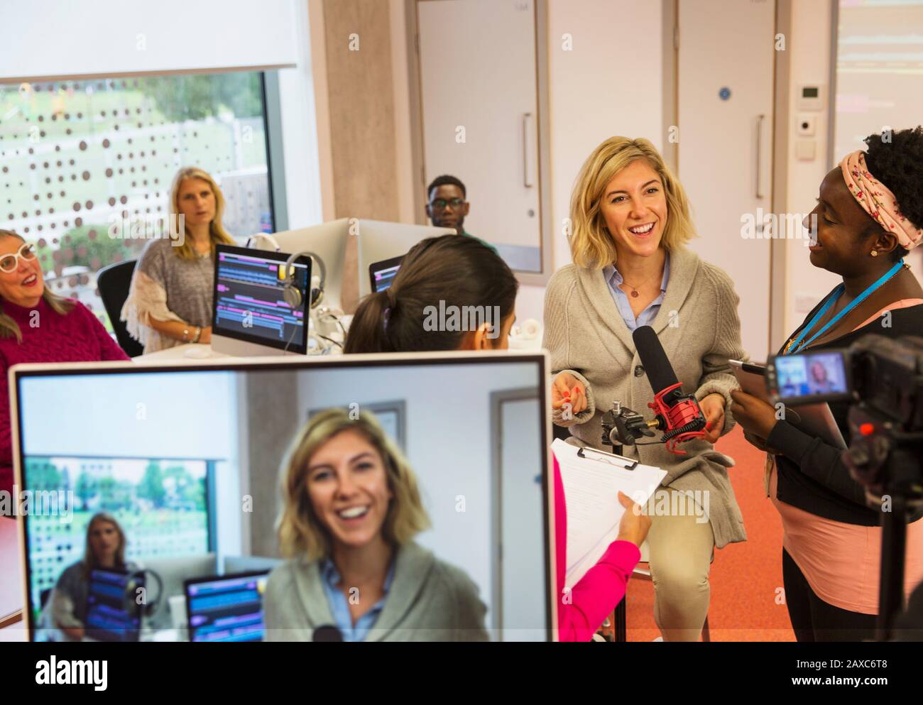 Studenti di giornalismo universitario di comunità sorridenti e fiduciosi filmano in classe Foto Stock