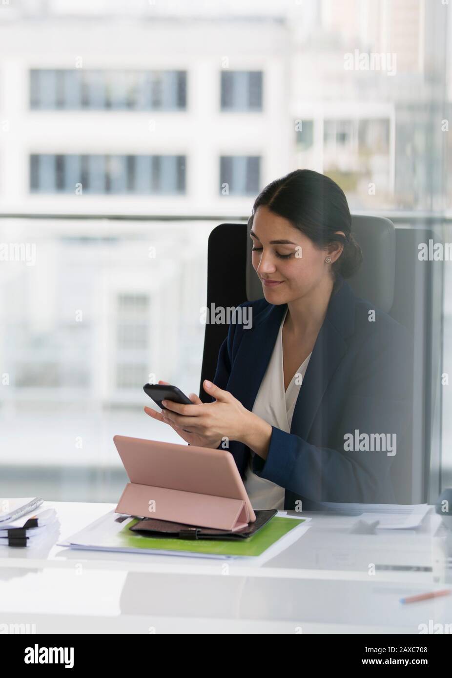 Imprenditrice utilizzando smart phone in sala conferenze Foto Stock