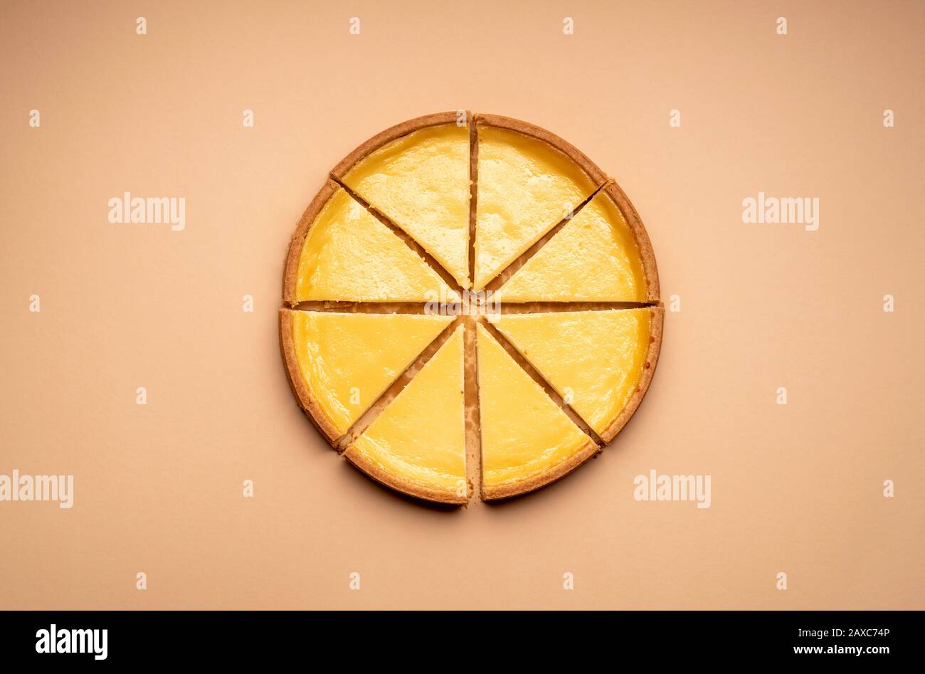 Cheesecake tagliato in 8 fette uguali, su un tavolo giallo, fotografia minima. Dessert al formaggio di fama mondiale. Dolci fatti in casa. Foto Stock