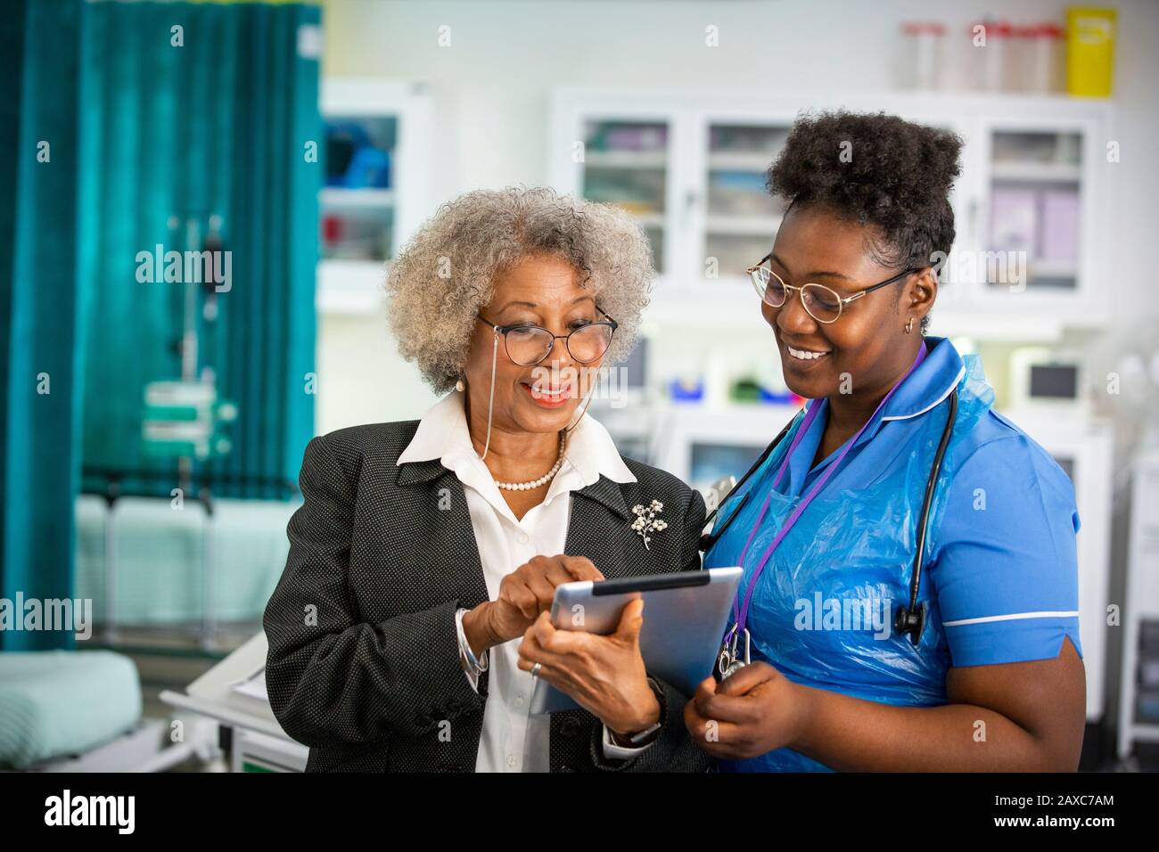 Medico e infermiere di sesso femminile che utilizza una compressa digitale in ospedale Foto Stock