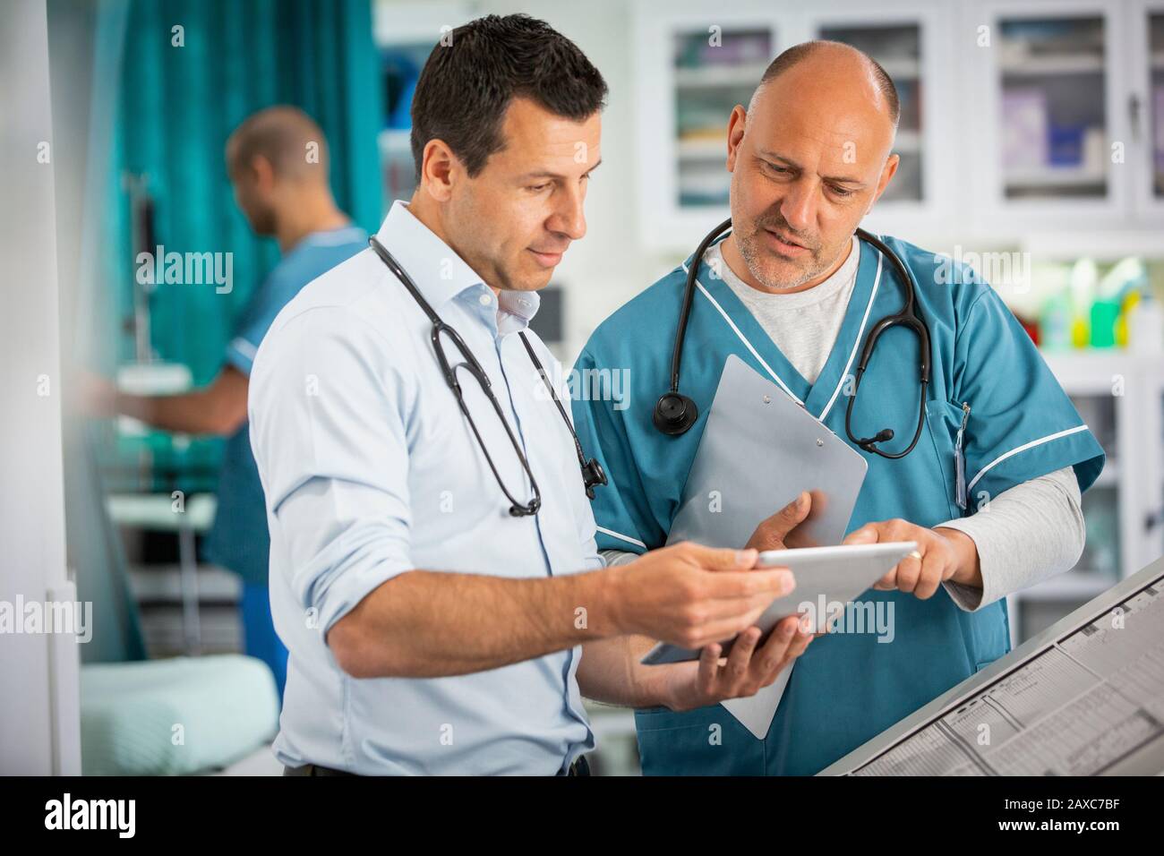 Medici di sesso maschile che utilizzano tablet digitali in ospedale Foto Stock
