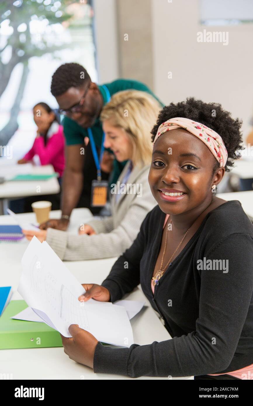 Ritratto studente sicuro femminile con documenti in classe Foto Stock