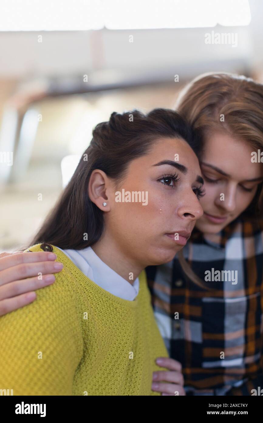 Giovane donna consolante piangendo amico Foto Stock