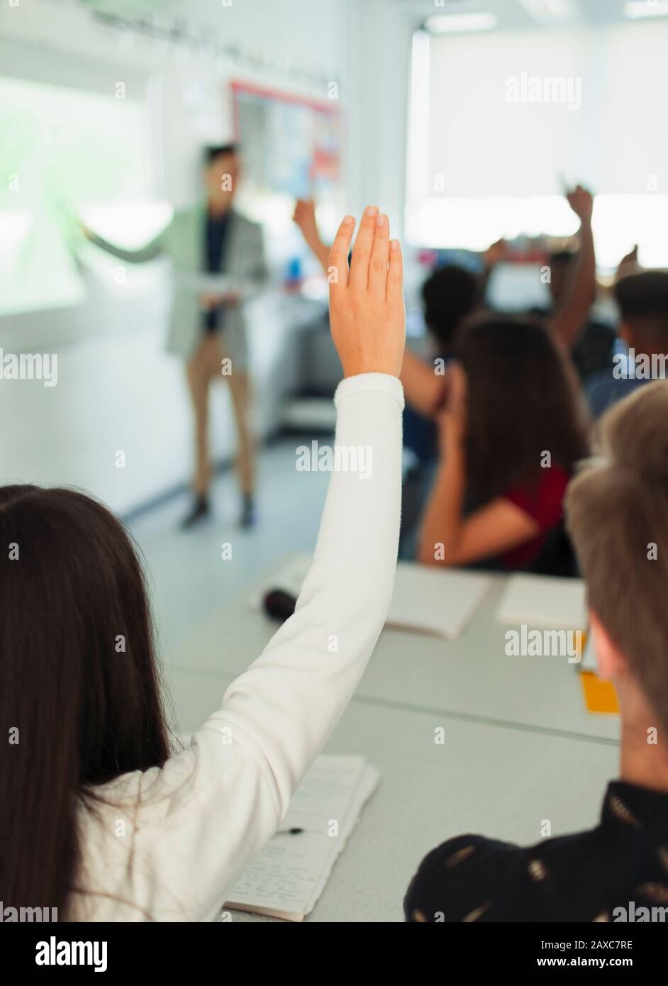 High School ragazza studente che alza la mano, facendo domande durante la lezione in classe Foto Stock