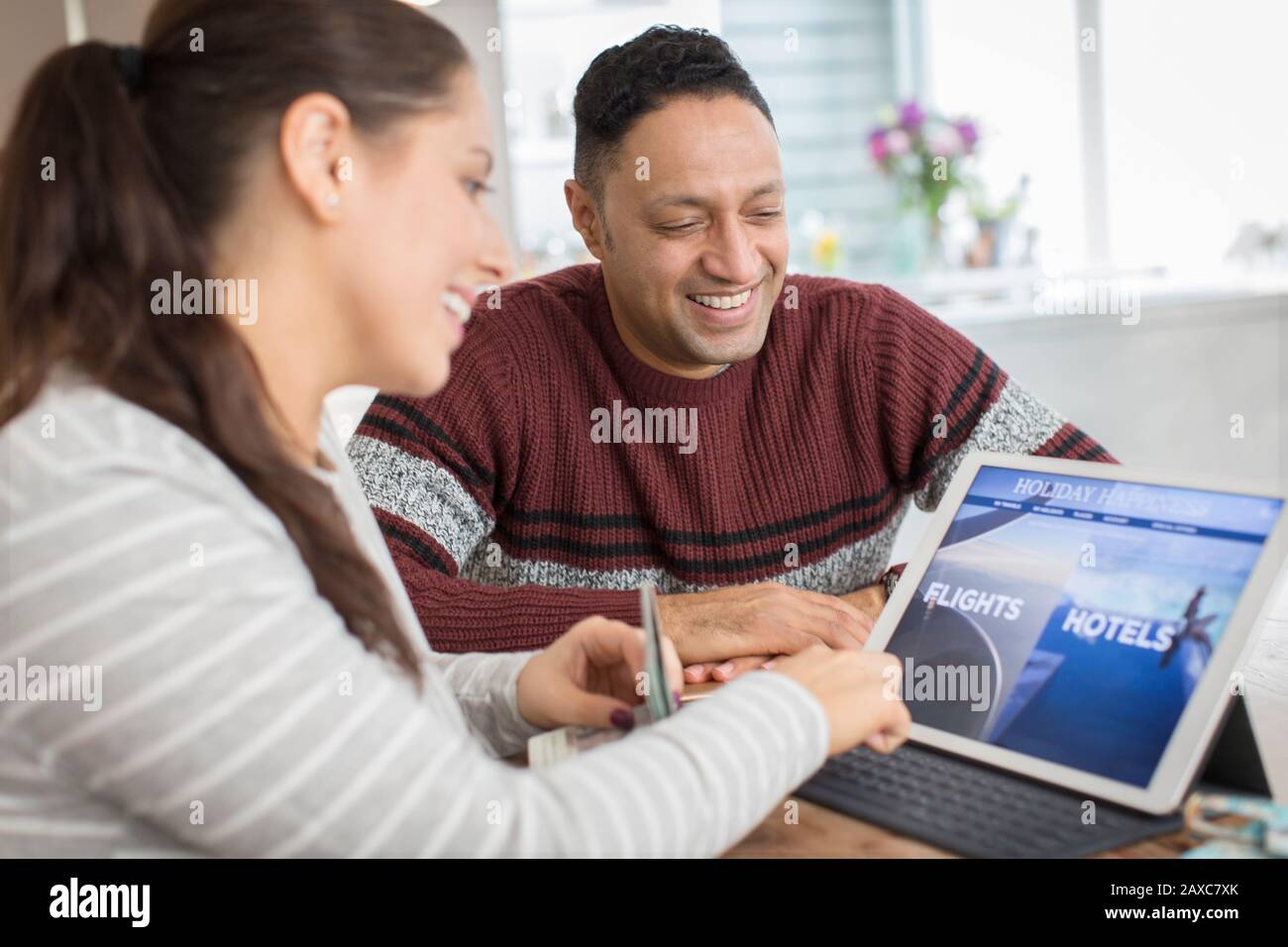 Felice coppia pianificazione vacanza al tablet digitale Foto Stock