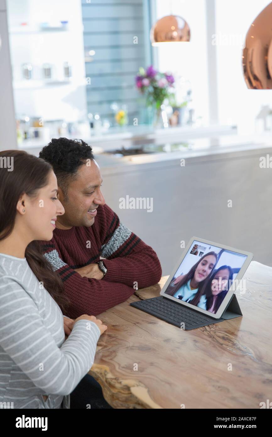 Conferenze video con i genitori con le figlie su tablet digitale Foto Stock