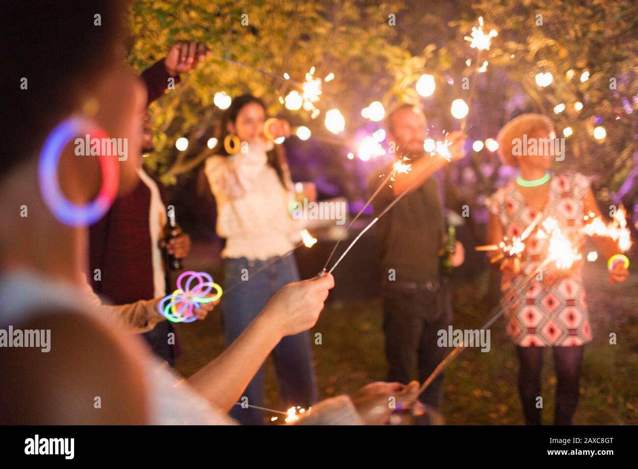Amici con gli sparklers che godono la festa del giardino Foto Stock