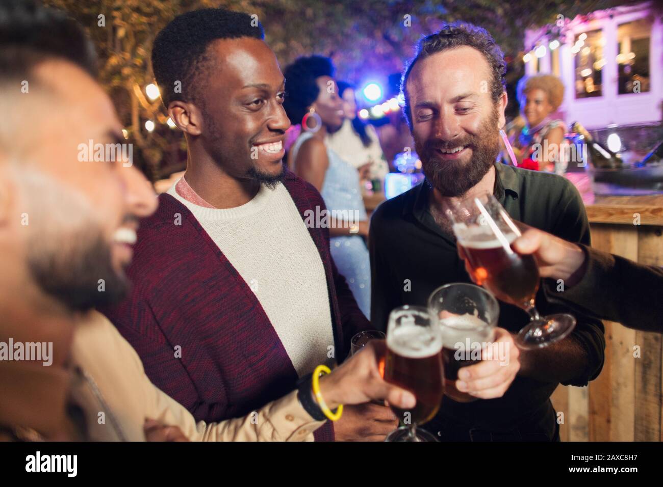 Amici maschi che bevono birre al party in giardino Foto Stock
